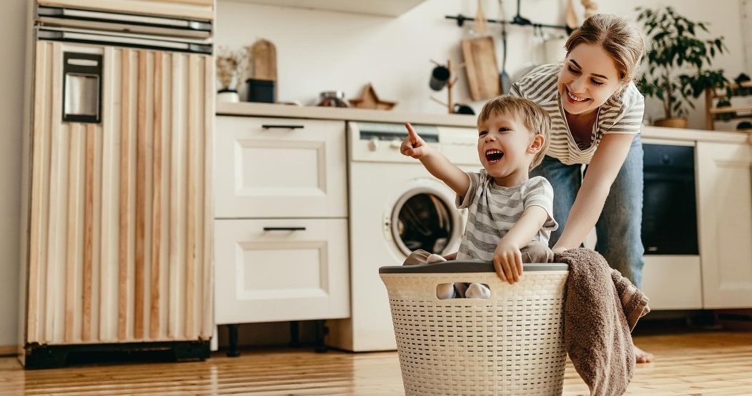 Junge Frau mit Kind im Wäschekorb